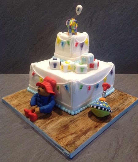 Elmer and Paddington Bear birthday cake with building blocks and spinning top